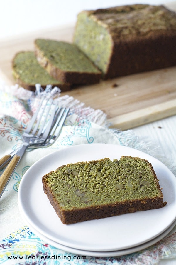 A slice of matcha green tea bread on a plate. It is next to the loaf.